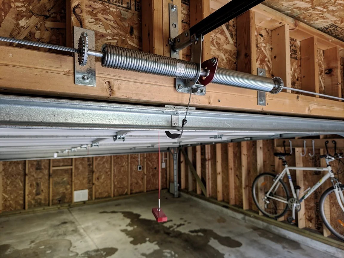 A garage door torsion spring is mounted above the garage door opening.